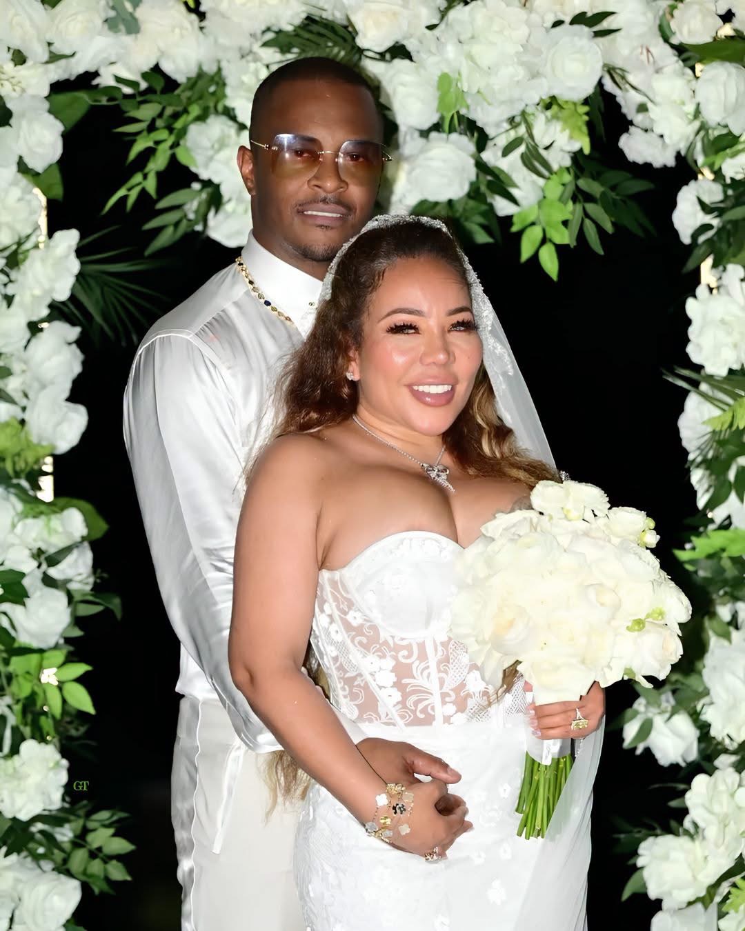 Tiny and T.I. under a white floral arch at their vow renewal