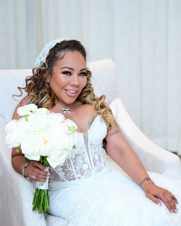 Tiny Harris in her custom bridal gown holding a white bouquet
